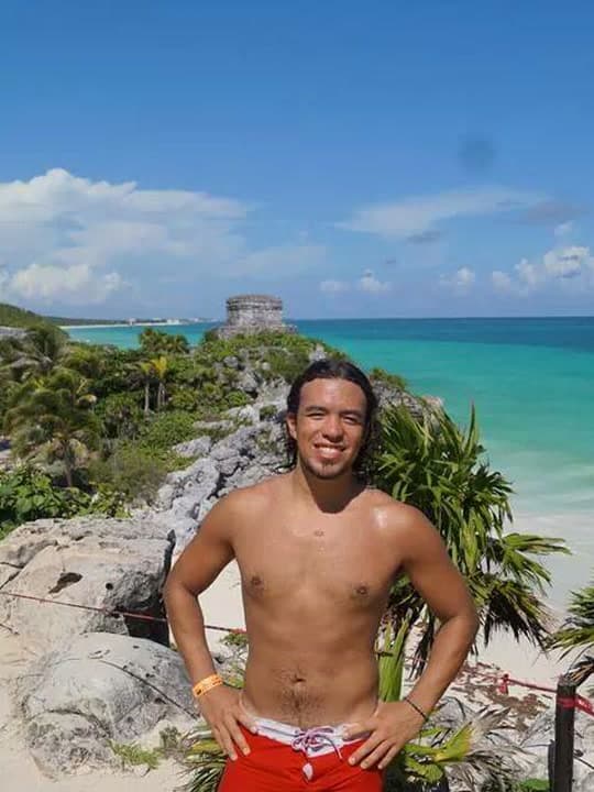 De pie en las ruinas del acantilado de Tulum con el Caribe detrás